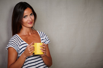 Satisfied brunette woman holding coffee cup