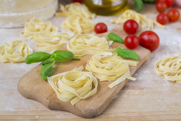 fresh homemade pasta machine pasta, basil,. tomatoes on a wooden