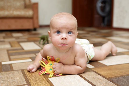 Surprised baby playing on the floor