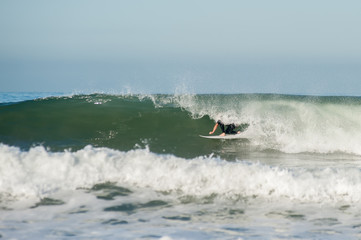 Surfer tucked in the tube of a wave going right.