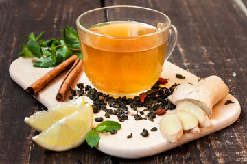 cup of green tea with lemon, ginger, cinnamon and mint