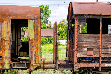 Explore the haunting allure of a pair of abandoned wagons in rusty condition captured through a medium telephoto lens from a small distance evoking a sense of forgotten history and the passage of time