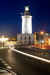 Fototapeta na wymiar Lighthouse in Malaga, Andalusia, Spain. Night lights in the port.