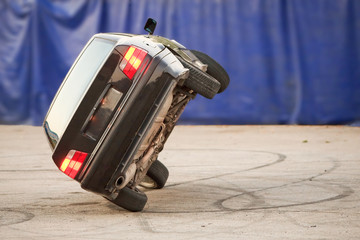 A car performing a dangerous stunt with two wheels in motion, showcasing a thrilling rollover demo...
