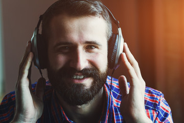 smiling bearded man  in headphones listening to music
