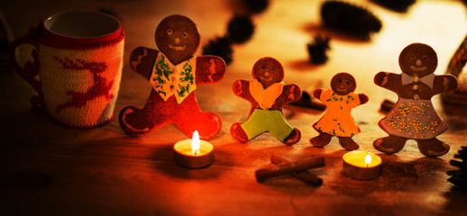 Christmas gingerbread men candles with cinnamon stars Pine twig Christmas ball on a wooden floor