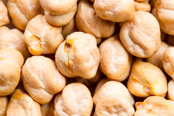 Fototapeta premium A detailed close-up of dried garbanzo chickpeas (Cicer arietinum) showing their wrinkled beige surfaces and natural texture, the uniform earthy-toned legumes evoking a rustic wholesome mood.