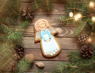 gingerbread handmade angel on the wooden background with fir branches