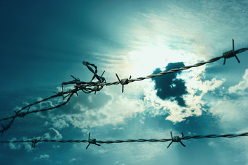 Stacheldraht vor bedrohlichem Himmel