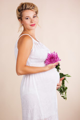 Pregnant woman with pink golden-daisy flower