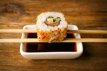 Roll with sauce and sticks on wooden table close up