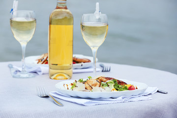 Tasty salad with wine on white served table