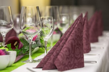 Gläser und Servietten auf gedecktem Tisch