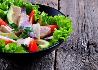Healthy salad of avocado, tomatoes, canned tuna, onions and lettuce with parmesan, parsley and olive oil