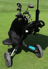 Golf bag with clubs on green field, close up