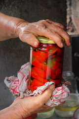 Old woman holding a jar of red pepper