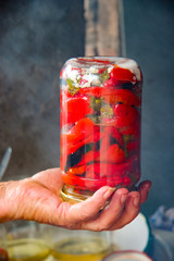 Old woman holding a jar of red pepper