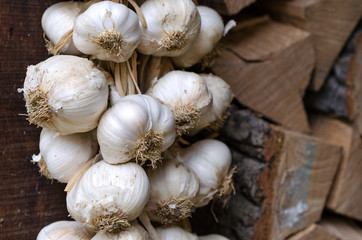 Garlic on a rope hanging in the pantry. Firewood in the background