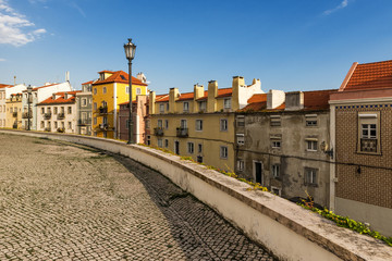 Fototapeta na wymiar Street in Alfama, Lisbon, with old cobblestone and tiles
