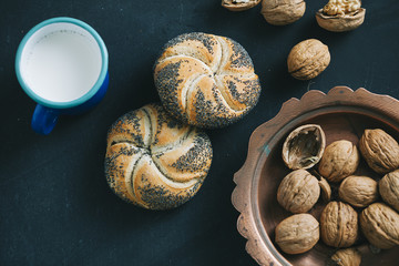breakfast with pastry walnut and milk on dark wooden table