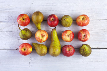 Apples and pears whole shot from above on white wooden boards