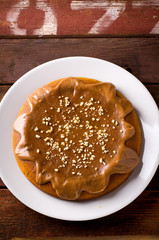 Pumpkin cake with caramel and peanuts on wooden table