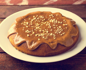 Pumpkin cake with caramel and peanuts on wooden table
