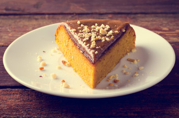 Pumpkin cake with caramel and peanuts on wooden table