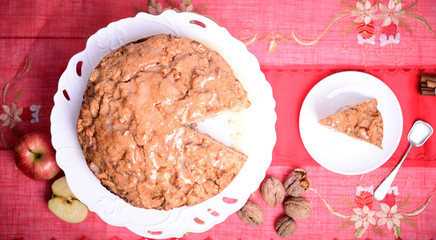 Fresh Christmas cake with apples and walnuts on table