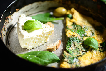 Fresh white cheese with scrambled eggs and spinach closeup