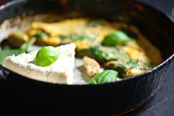 Fresh white cheese with scrambled eggs and spinach closeup