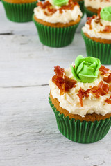 Cupcakes cabbage and bacon shot on white wooden boards front on and at an angle portrait