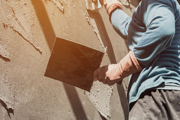 plasterer concrete worker at wall of home construction building