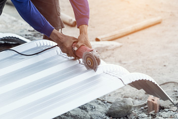 construction worker cutting roof for building