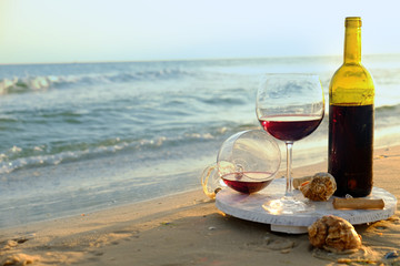 Wine bottle and glasses on the seashore