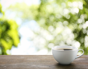 Cup of coffee on table on bright background