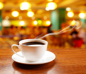 Cup of coffee on table on bright background