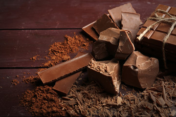 Black chocolate pieces with spices on wooden background