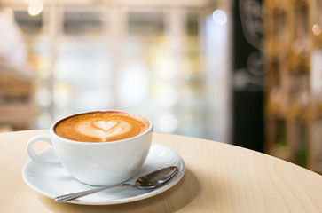 Hot art Latte Coffee in a cup on wooden table and Coffee shop bl
