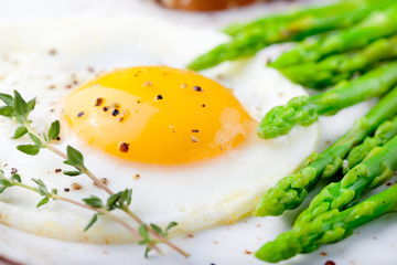 Green asparagus,fried egg and bread with butter.
