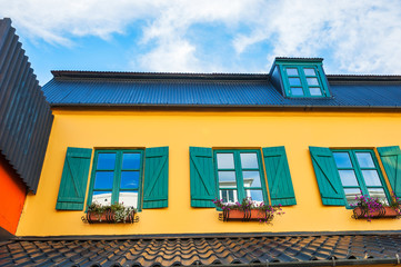 Fototapeta na wymiar Yellow house with green windows. Reykjavik, Iceland