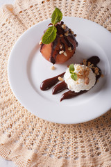 poached pear with chocolate and ice cream on a plate. vertical top view 
