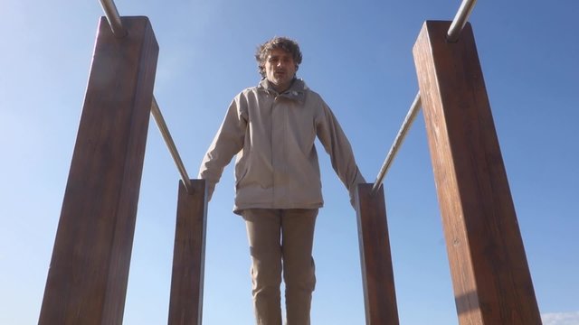 man exercising on parallel bars outdoors