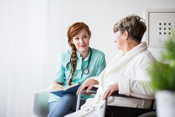 Obraz premium Woman on wheelchair with doctor