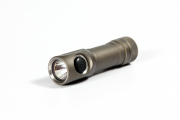 small grey metal flashlight on white background