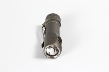 small grey metal flashlight on white background