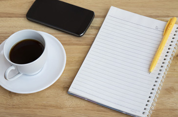 Obraz na płótnie Canvas Smartphone, pen and cup of coffee on wood table - Work office supplies 