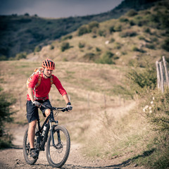 Obraz premium Mountain bike rider on country road, track trail in inspirationa