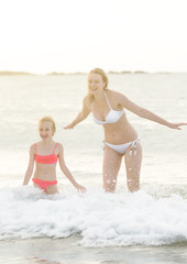 Woman and her daughter having fun in the sea.