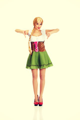 Woman in Bavarian dress with thumbs down.